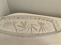 Photo of clear decorative crystal plate with intricate patterns.