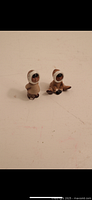 Two ceramic Eskimo figurines viewed frontally showing detailed faces and clothing.