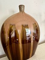 Front view of the ceramic vase showing its oval shape and brown/tan vertical streak glaze.