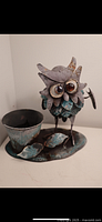 Metal owl planter with attached planter cup and tray base, showing rust spots on the owl and planter surface.
