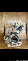 Front view of the mountain lion resin figurine showing facial expression, body posture and tree branch support.