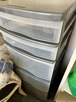 Full view of the plastic storage unit showing all five translucent drawers and white plastic frame.