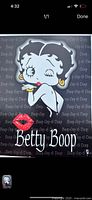 Photo shows a rectangular tin sign featuring Betty Boop with a red lipstick kiss and text.