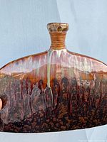 Close-up photo of the ceramic vase showing the drip glaze and narrow neck detail.