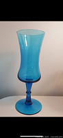 Side angle showing the overall height and shape of the vintage blue glass pedestal vase, highlighting the flared top and smooth finish.