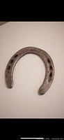 Top view of a horseshoe with visible rust and some wear marks on the metal surface.