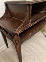 Close-up view of the table corner showing curved wood section and worn finish with flaking and scratches.