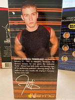 Close-up photo of Justin Timberlake bobblehead box back showing biographical text and signature.