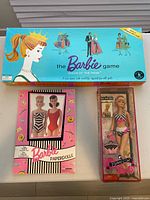 Front view of all three items: Barbie Game box, Barbie Paperdolls booklet, Bathing Suit Barbie doll in packaging.