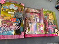 Three boxed Barbie doll sets: Pet Doctor, Barbie & Tanner the dog, Stylin Pup with grooming accessories.