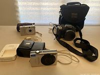 Overview of all three cameras with cases, cables and charger