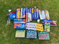 Overview photo showing all kitchen wraps, papers, disposable chopsticks, beverage napkins, wipes, and beverage koozies arranged on grass.