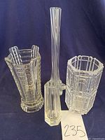 Four vases displayed against black background showing different shapes and cut glass patterns