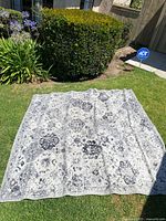 Rug laid flat on grass outdoors, showing full size and pattern.