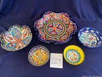 Group photo of five decorative handmade pottery bowls showing colors and shapes
