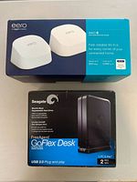Photo showing both Eero 6 Dual Band Mesh WiFi system box and Seagate 2TB FreeAgent GoFlex Desk external hard drive box stacked together on a flat surface.