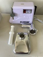 Front and side view of the STX TurboForce 3000 Series electric meat grinder showing main unit, food pusher, tray, and grinding attachment assembled separately.