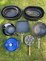 Full overview of all cookware items including roasting pans, grill pan, wok, Dutch oven, and cast iron pans with molds for round items.