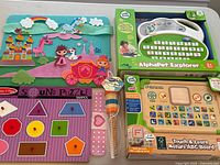 Photo showing all items in the lot including the felt board with unicorns and princesses, LeapFrog Alphabet Explorer, Touch & Learn Nature ABC Board, Sound Puzzle, and sensory ball.