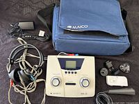 Overview of audiometer console, headphones, power adapter, plug adapters, battery pack, and carrying case