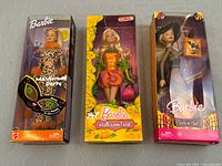 Three unopened Mattel Barbie dolls in original boxes showing front of packaging and dolls inside.