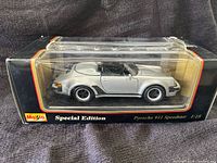 Clear view of the model car in original black packaging labeled Maisto Special Edition, silver Porsche 911 Speedster in 1:18 scale.
