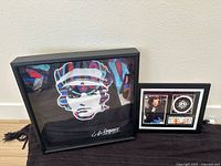 Image of framed signed Ringo Starr Beatles-themed t-shirt with psychedelic portrait and signature in white ink.