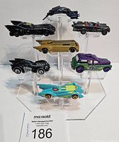 Full set of six Batman-themed diecast cars arranged on clear display stands showing various Batmobile and villain-themed styles.