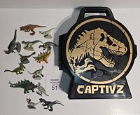 Front side of the Captivz Jurassic Park World carry case with dinosaur skeleton design and 15 dinosaur figures displayed beside it.