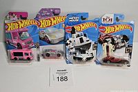 Front view of four sealed Hot Wheels cars with Barbie, Barbie Extra, Mickey Mouse, and 101 Dalmatians themes.