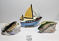 Photo showing all three vintage lake-themed planters - one sail boat and two fish-shaped planters.