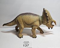 Side view of the large Triceratops dinosaur toy showing details of the body texture, coloration, and overall shape