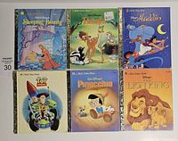 Six Little Golden Books with Disney titles Sleeping Beauty, Bambi, Aladdin, Toy Story, Pinocchio, and The Lion King, all showing front cover artwork featuring classic characters.