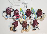 Seven California Raisins PVC figurines in various musical poses and wearing sunglasses or gloves.