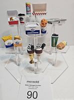 Overview of the mini brand food-themed collectibles arranged on clear acrylic stands, showing fast food items, drinks, and desserts.