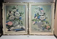 Front view of two framed vintage floral paint by number paintings showing flowers in vases with soft color palette.