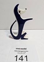 Side view of blue and white stylized dog figurine showing shape and color.