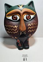 Front view of painted pottery cat showing detailed facial features, eyes, nose, and body decoration