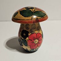 Front and side view showing painted floral designs on the mushroom figurine