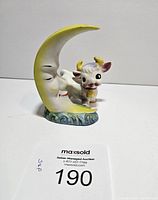 Front view of the moon and cow salt and pepper shakers showing colors and design