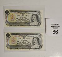 Two uncirculated Canadian one dollar bills front side with portrait of Queen Elizabeth II and denomination visible.