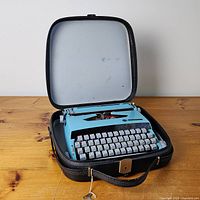 Typewriter inside open case showing overall lot