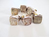 Front view of six identical sterling silver rings showing menorah design