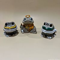 Front view of all three frog figurines