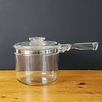 Right side view of glass Pyrex Flameware saucepan with lid showing full profile and handle