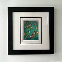 Full view of framed Norval Morrisseau print with black frame and white mat