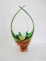 Full view of amber-green art glass vase with crossed handles