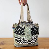 Front view of Laurel Burch cat motif fabric handbag showing design and straps