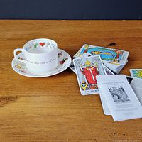 Cup on saucer beside spread tarot cards