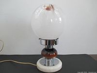 Full view of lamp showing globe shade, marble base and cord